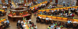 A photo of a large university library, featuring lots of students at work