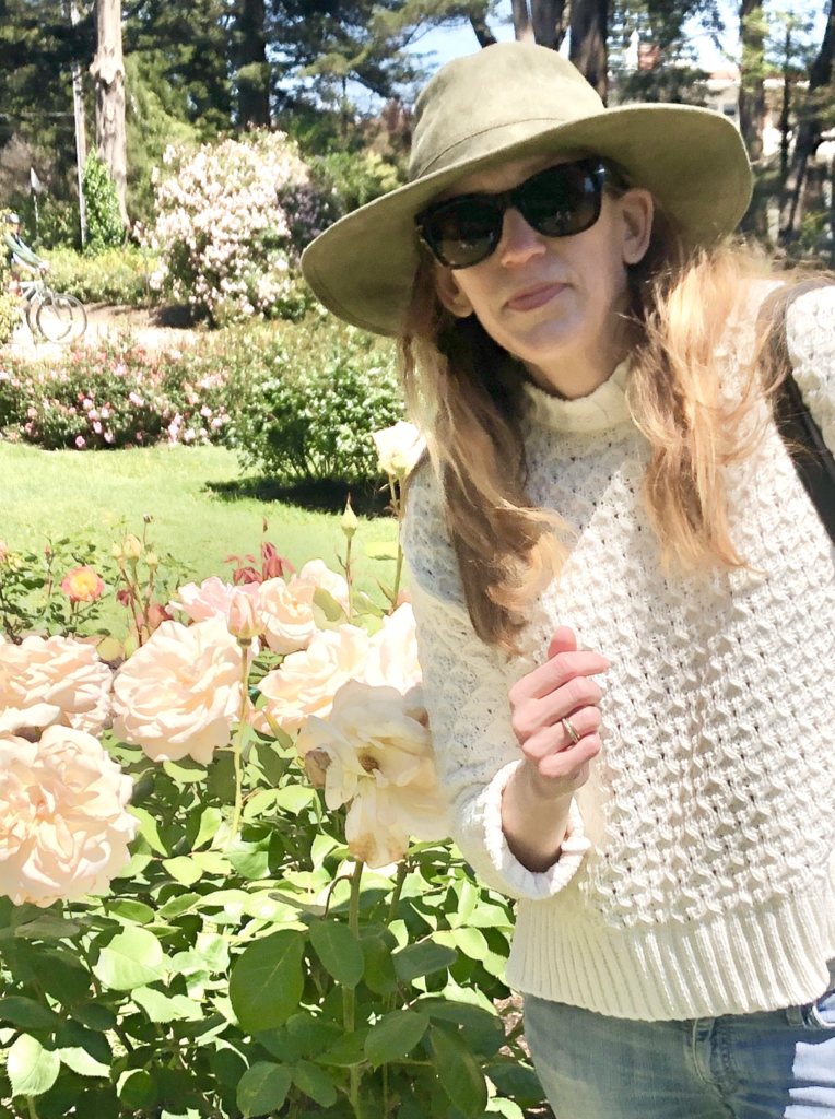 Laura Moorhead, in a hat and sunglasses, enjoys the sun at Golden Gate Park