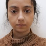 The scholarly communication lab's Huma Zafar poses in a brown turtle neck against a white background